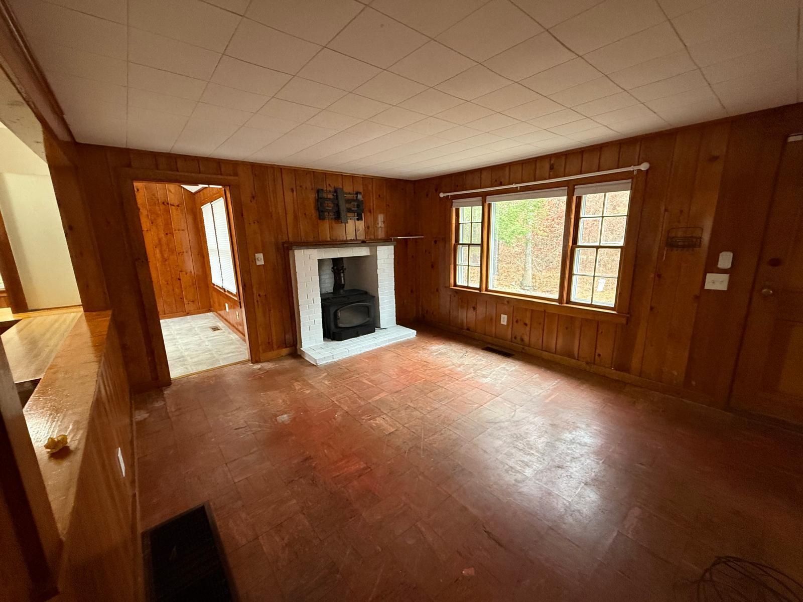 86 Lowell Road Mashpee, MA 02649 - Photo 7 of 18 a view of an empty room with a fireplace and a window