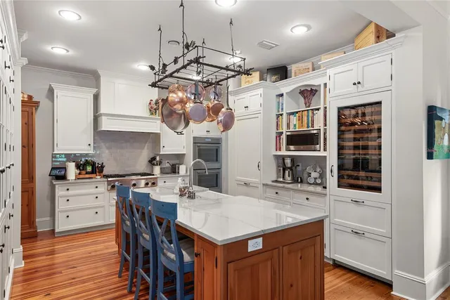 a kitchen that has a lot of cabinets in it and wooden floors