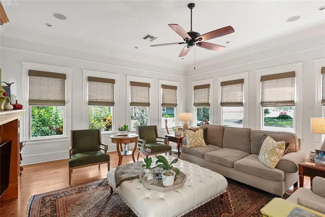 a living room with furniture a ceiling fan and a large window