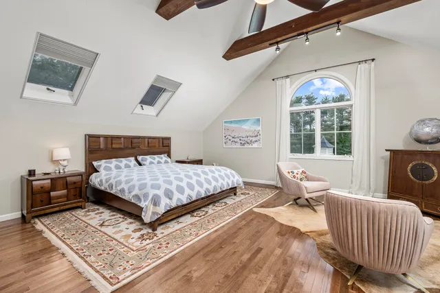 a bedroom with a bed a mirror and a window