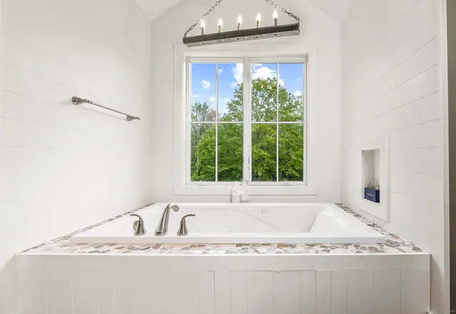 a white bath tub sitting next to a window