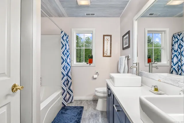 a bathroom with a sink a toilet and a large mirror