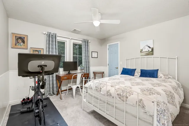 a bedroom with a bed a mirror and desk