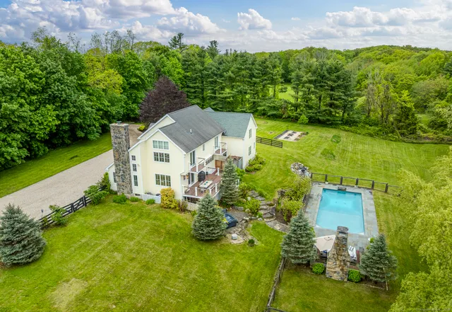 an aerial view of a house with a garden and lake view