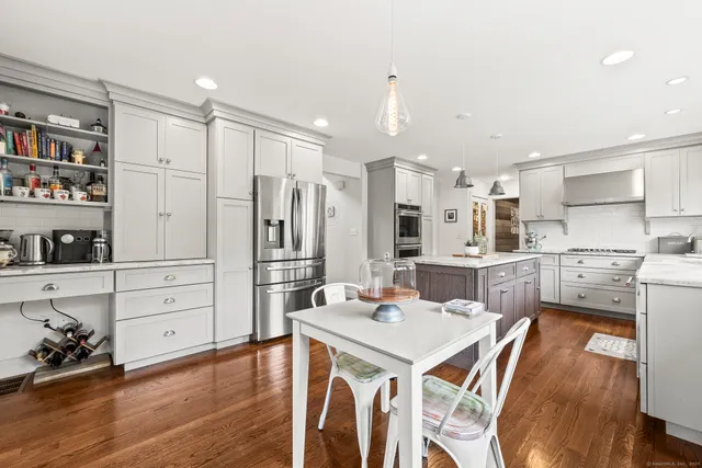 a kitchen with a table chairs refrigerator and cabinets