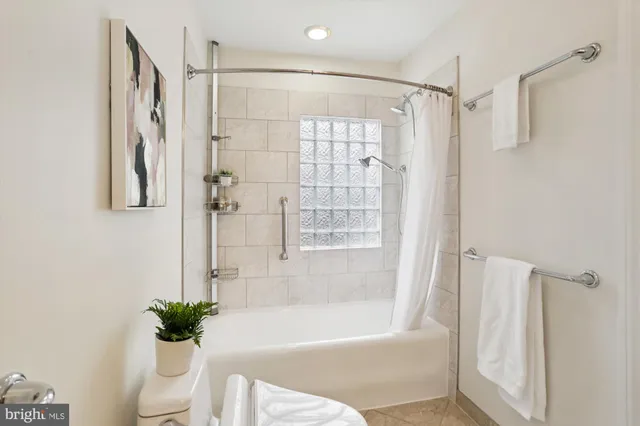 a living room with furniture a chandelier and kitchen view