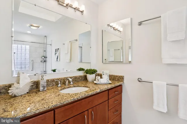 a kitchen with stainless steel appliances granite countertop a sink dishwasher a microwave oven a dining table and chairs with wooden floor