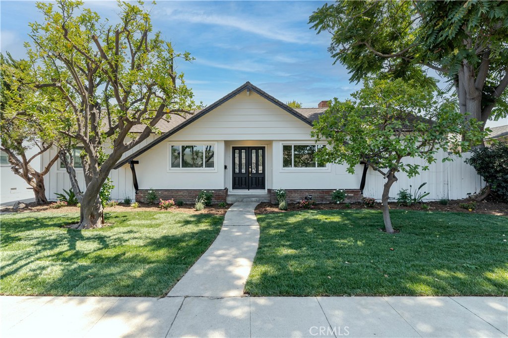 a house with green field in front of it