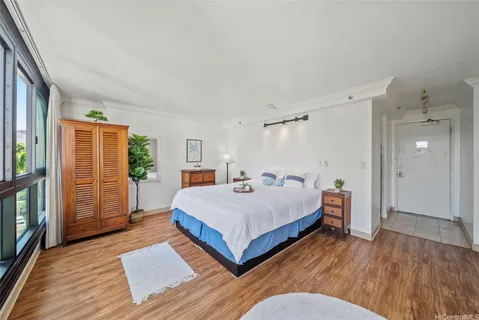 a spacious bedroom with a bed and a wooden floor