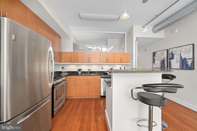 a kitchen with stainless steel appliances granite countertop a stove a sink and a refrigerator