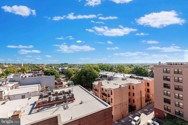 a view of a white house with a fountain and a potted plant