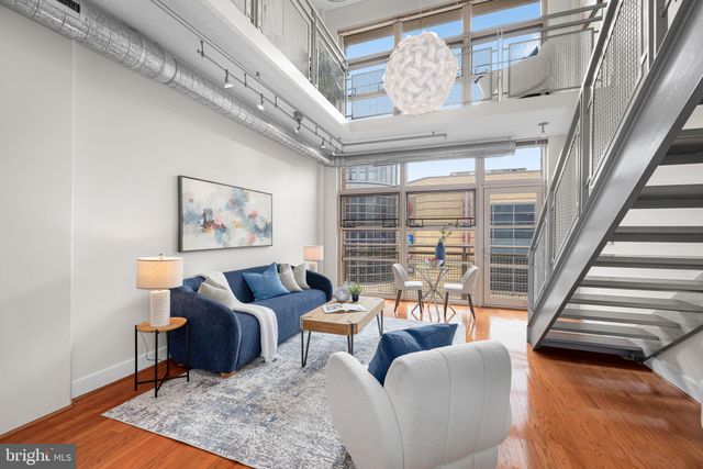 a kitchen with stainless steel appliances a stove a refrigerator a dining table and chairs with wooden floor