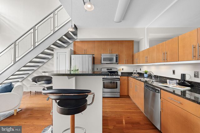a kitchen with granite countertop appliances a sink and a refrigerator