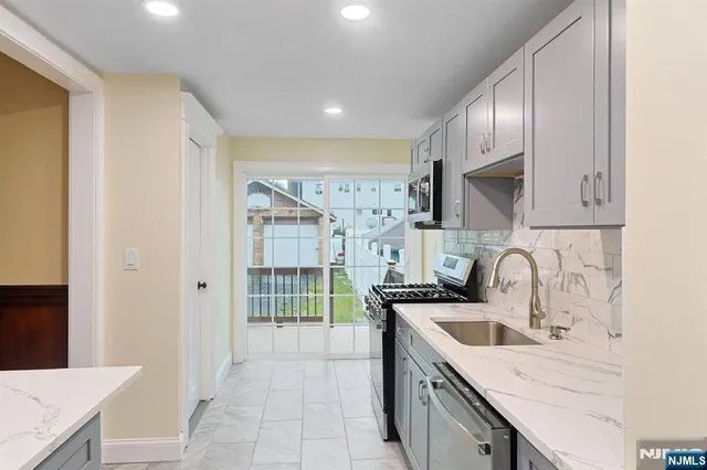 a kitchen with stainless steel appliances granite countertop a sink and cabinets