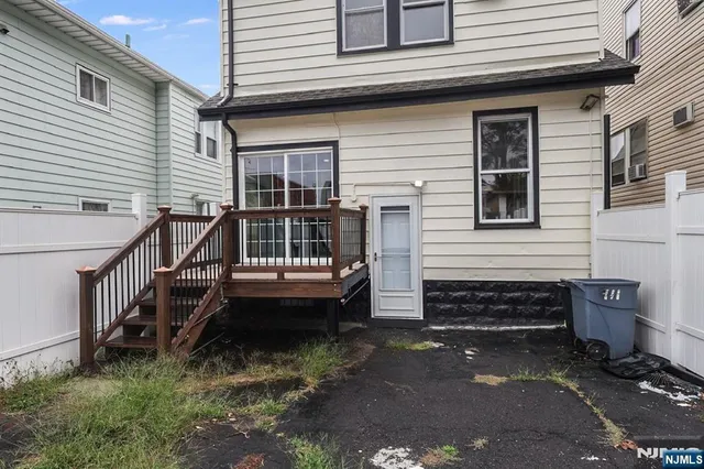 a view of a house with a yard and wooden fence