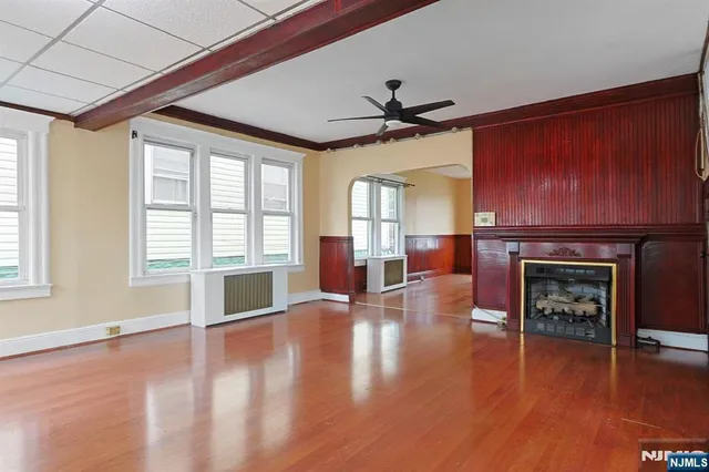 a view of a livingroom with furniture a fireplace and wooden floor