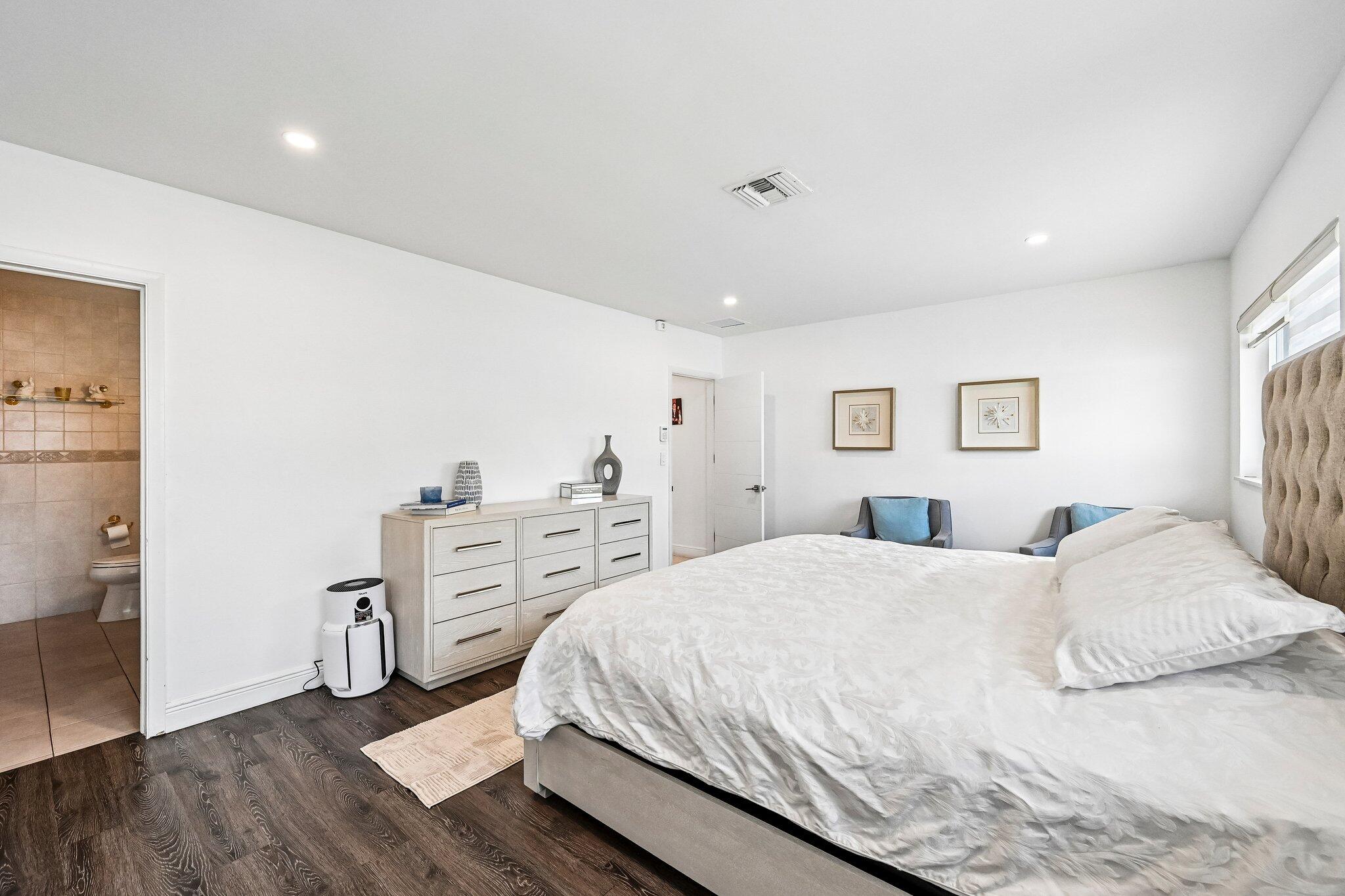 2940 Northeast 39th Court Lighthouse Point, FL 33064 - Photo 19 of 42 a spacious bedroom with a bed and a cabinets