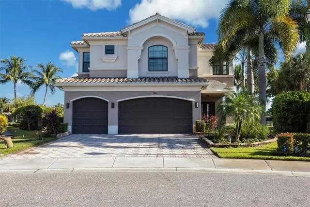 a view of a house with a yard and palm trees