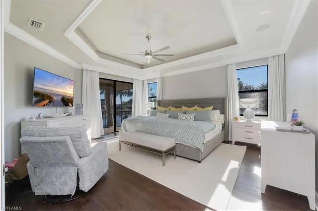 a bedroom with a large bed a flat screen tv and couches