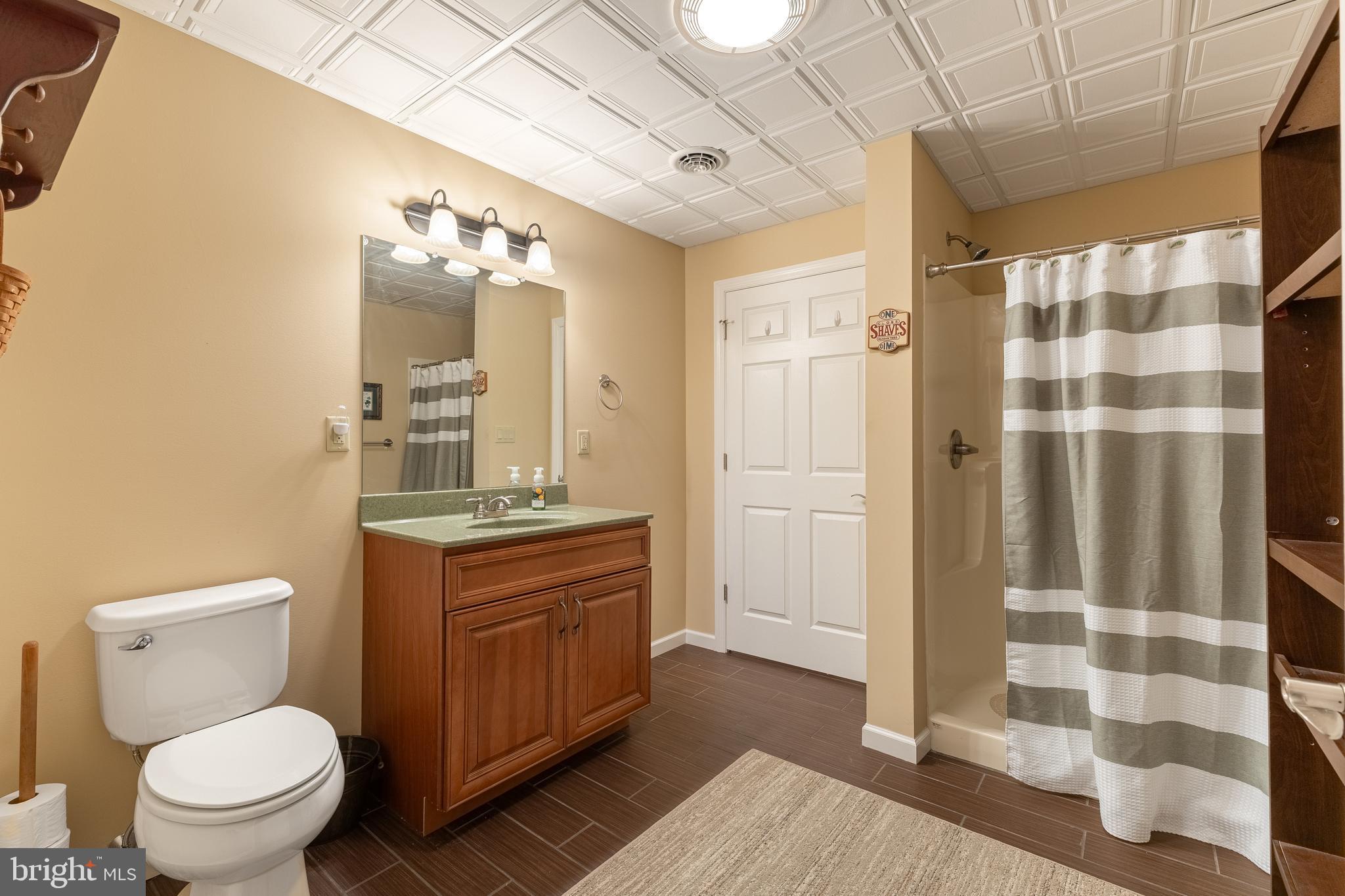 169 Quarry Street Bellefonte, PA 16823 - Photo 25 of 30 a bathroom with a granite countertop toilet a sink a mirror and a shower