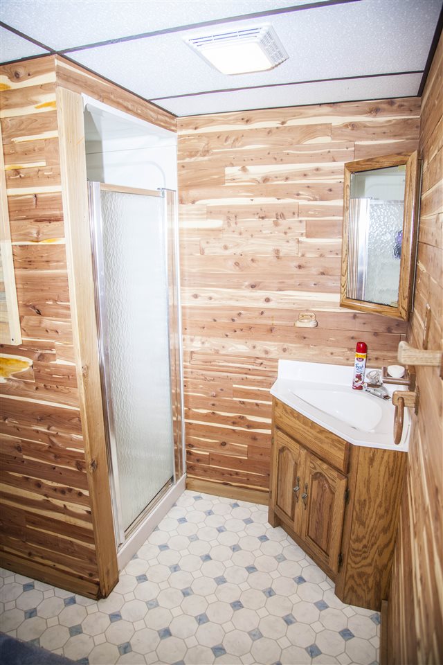 13026 West State Road Winnebago, IL 61088 - Photo 13 of 24 a bathroom with a sink a mirror and a shower