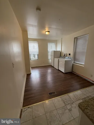 a kitchen with stainless steel appliances wooden floor and a sink