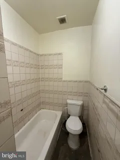 a bathroom with a toilet and a bathtub