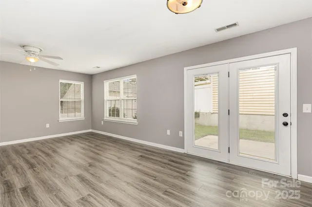 a view of an empty room with glass door and windows