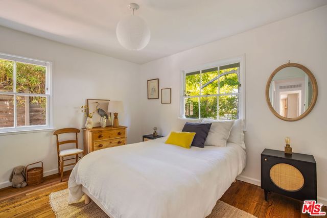 a bedroom with a bed and dresser with mirror