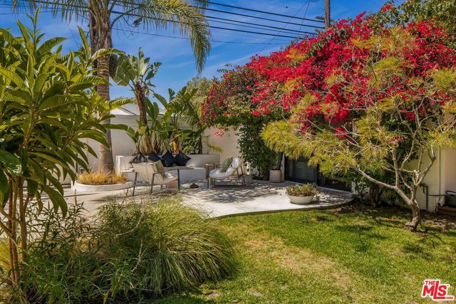 a front view of a house with a yard and fountain