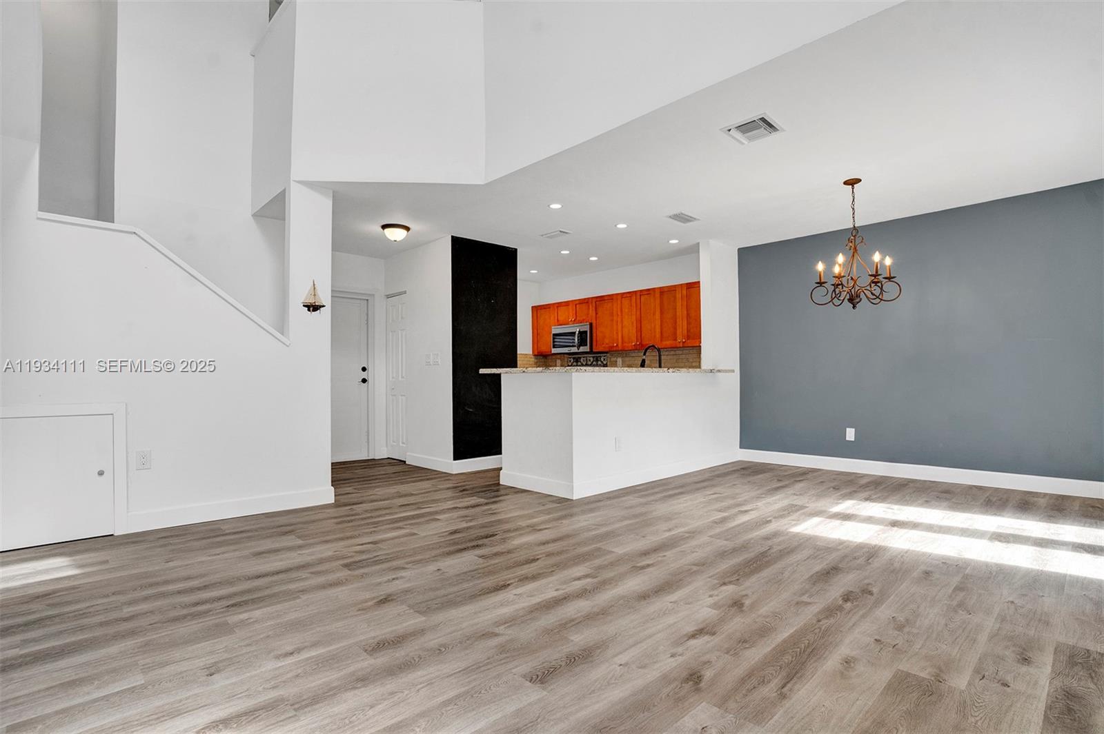 20985 Southwest 84th Avenue Cutler Bay, FL 33189 - Photo 11 of 36 an empty room with wooden floor and appliances