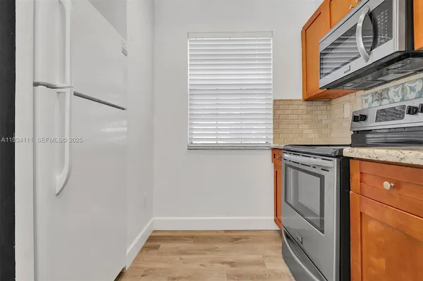 a kitchen with stainless steel appliances granite countertop a refrigerator and a stove