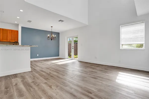 a view of a kitchen with wooden floor and a window
