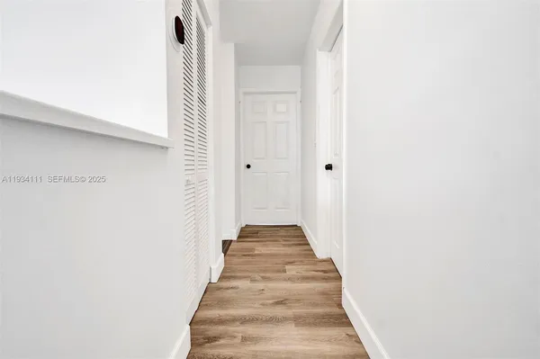 a view of a hallway with wooden floor and staircase