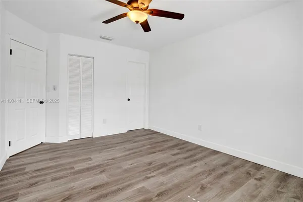 a view of an empty room with wooden floor