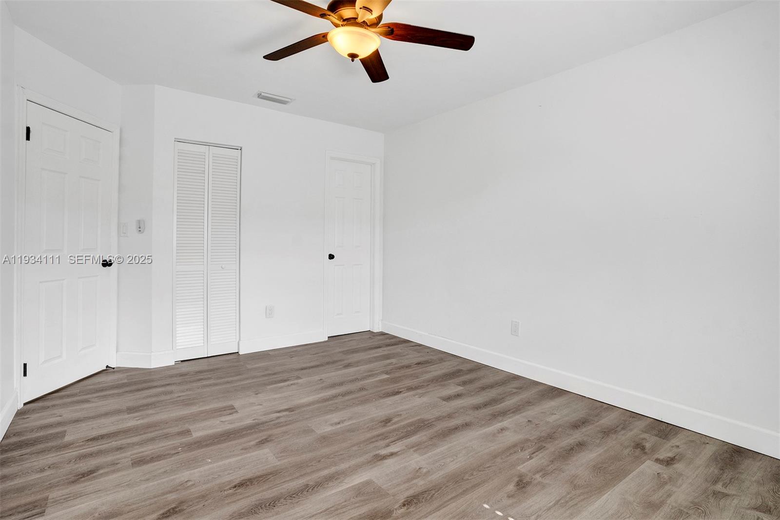 20985 Southwest 84th Avenue Cutler Bay, FL 33189 - Photo 26 of 36 a view of an empty room with wooden floor