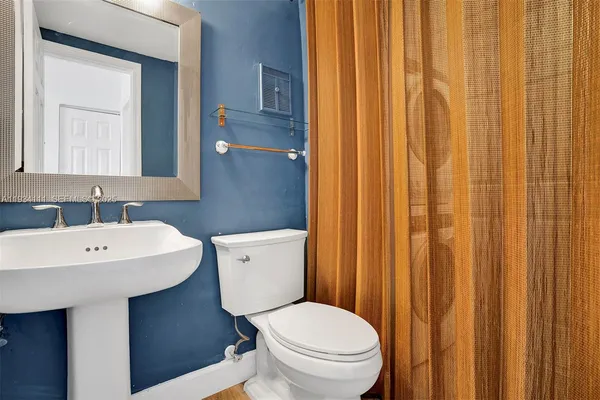 a bathroom with a toilet a sink and a mirror
