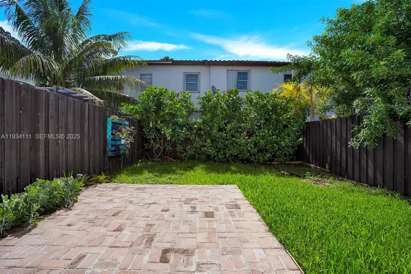 a view of a back yard with a wooden fence