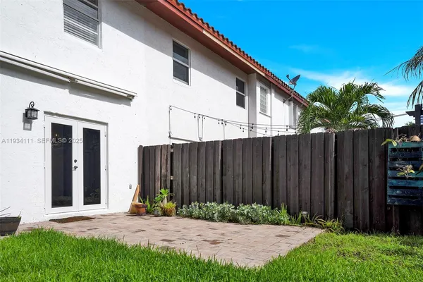 a backyard of a house with plants and wooden fence
