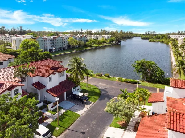 an aerial view of a house with outdoor space and lake view in back
