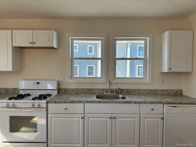 a kitchen with granite countertop cabinets stainless steel appliances and a sink