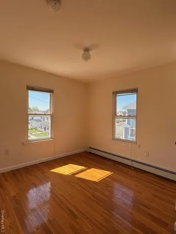 a view of a big room with wooden floor and windows