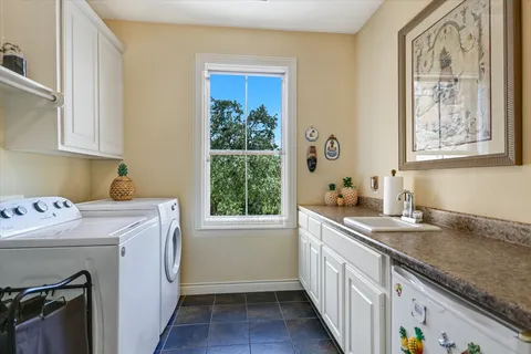 a utility room with a sink window and washer