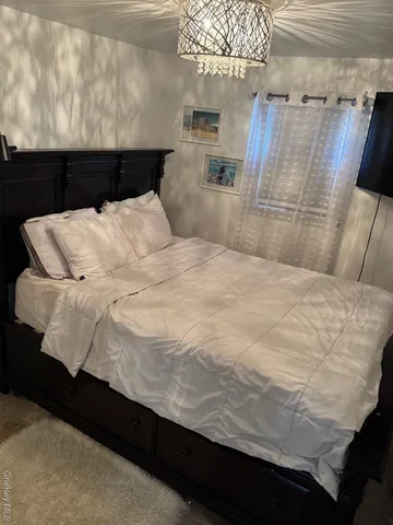 a bed sitting in a bedroom next to a chandelier