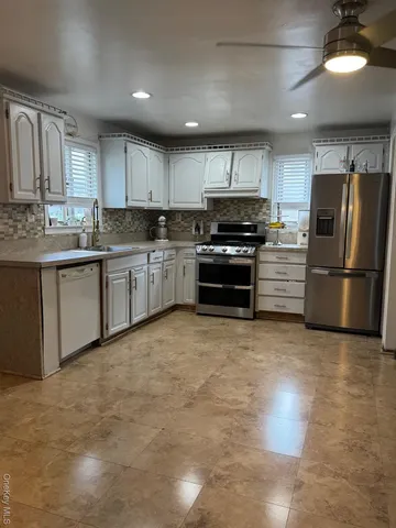 a kitchen with stainless steel appliances granite countertop a refrigerator sink and stove