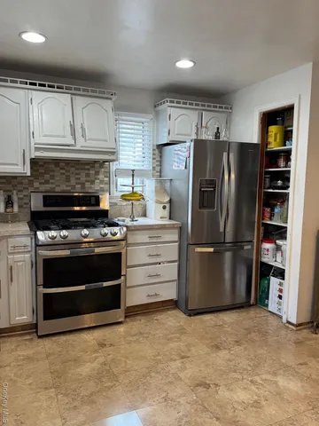 a kitchen with refrigerator a microwave and cabinets