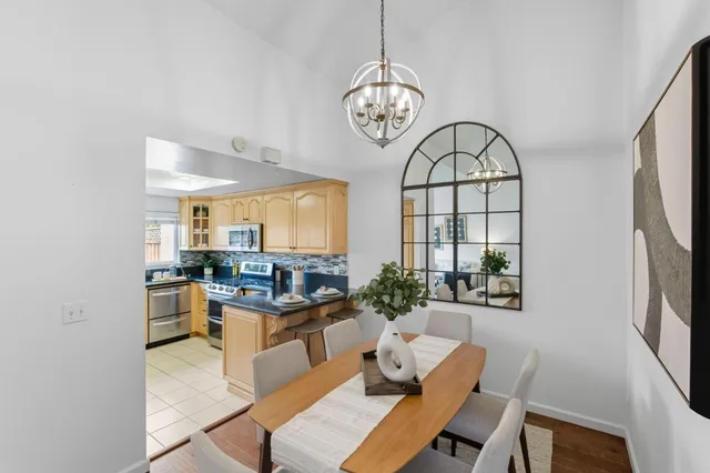 a view of a dining room with furniture a chandelier and wooden floor