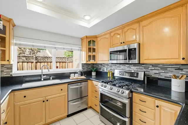 a kitchen with granite countertop a sink stainless steel appliances and cabinets
