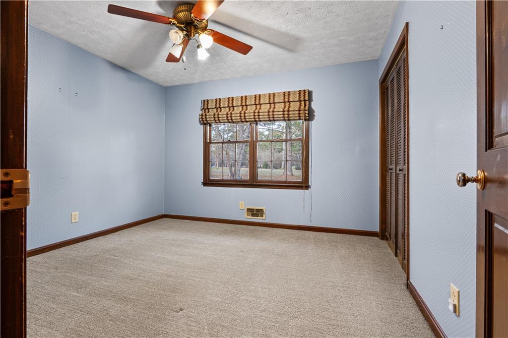 7085 Hobgood Road Fairburn, GA 30213 - Photo 18 of 40 an empty room with chandelier fan and windows