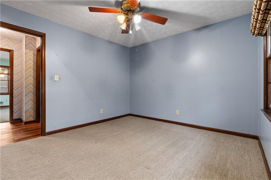 7085 Hobgood Road Fairburn, GA 30213 - Photo 20 of 40 an empty room with a chandelier fan and windows